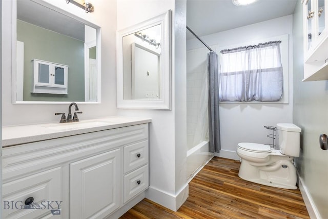 full bathroom featuring vanity, hardwood / wood-style flooring, shower / bath combination with curtain, and toilet