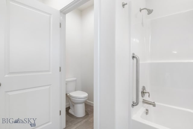 bathroom featuring toilet, hardwood / wood-style floors, and shower / tub combination