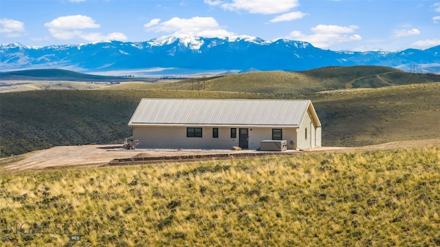 view of front of home featuring a patio area, a mountain view, and cooling unit