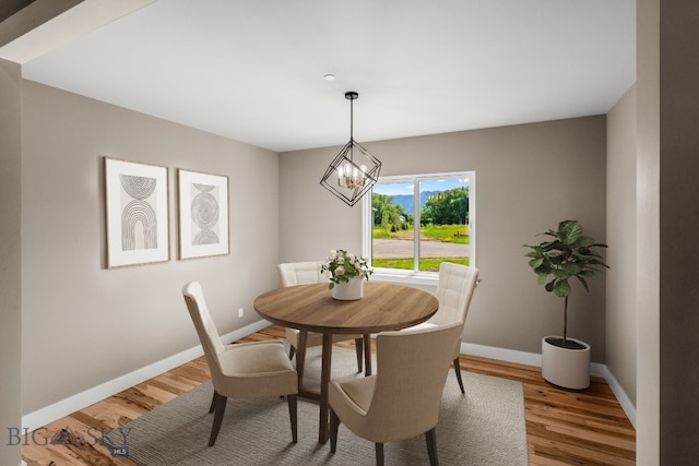 dining room with hardwood / wood-style floors and an inviting chandelier