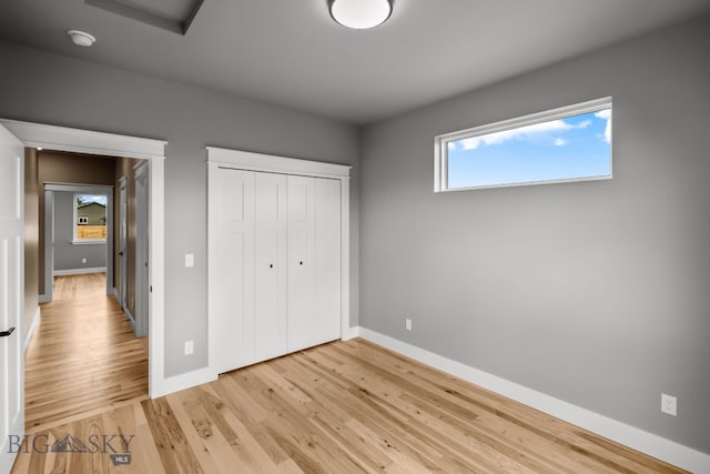 unfurnished bedroom with a closet and light hardwood / wood-style flooring