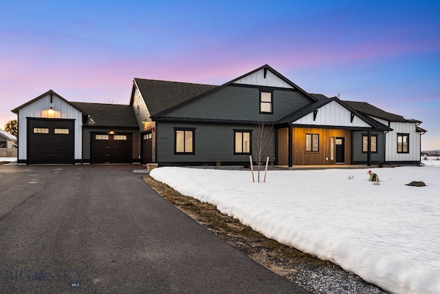 modern farmhouse style home with driveway, a shingled roof, a garage, and board and batten siding