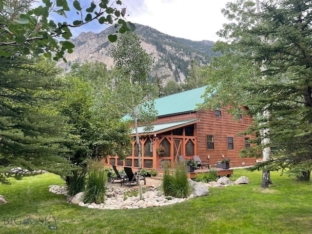 back of property featuring a lawn and a mountain view