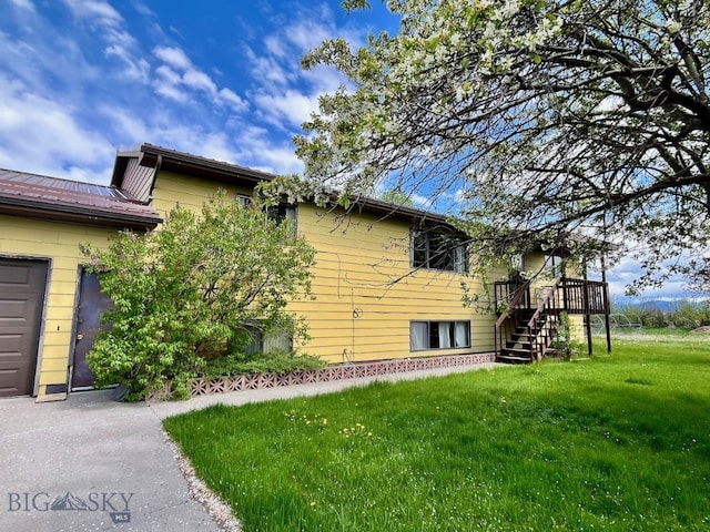 view of property exterior featuring a garage and a yard