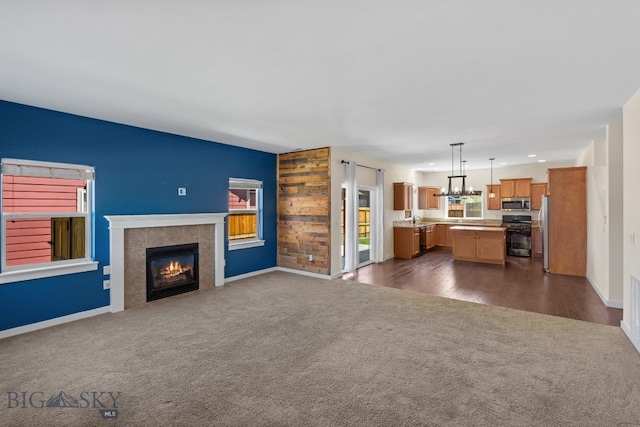 unfurnished living room featuring dark carpet and a tiled fireplace