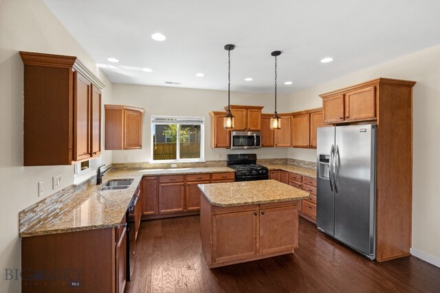 kitchen with black appliances, sink, hanging light fixtures, a kitchen island, and dark hardwood / wood-style flooring