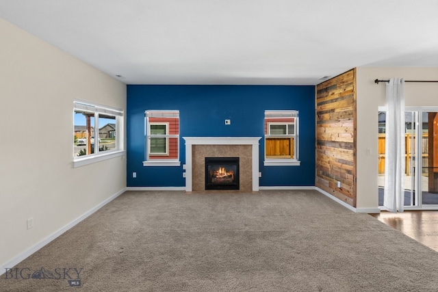 unfurnished living room with a tile fireplace and carpet floors