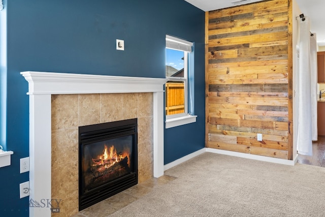 unfurnished living room featuring a fireplace, light carpet, and wood walls