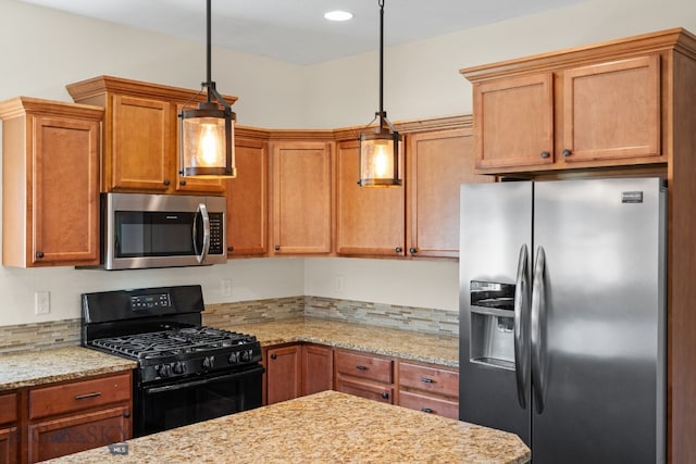 kitchen featuring pendant lighting, light stone counters, and appliances with stainless steel finishes