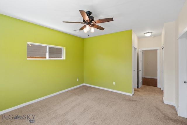 carpeted spare room featuring ceiling fan