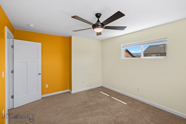 carpeted spare room featuring ceiling fan