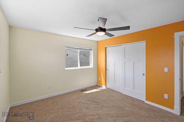 unfurnished bedroom featuring carpet, ceiling fan, and a closet