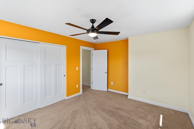 unfurnished bedroom with ceiling fan, light colored carpet, and a closet