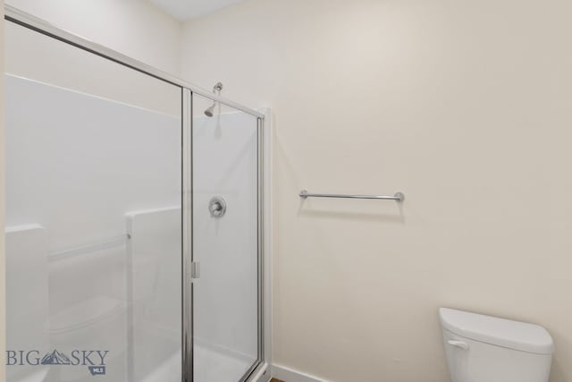 bathroom with toilet and a shower with door