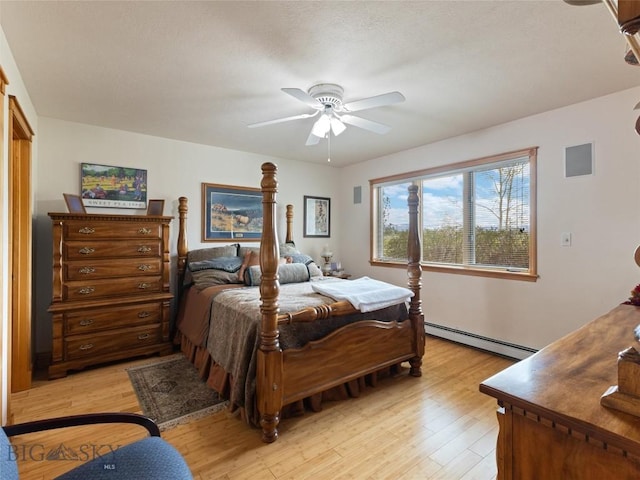 bedroom with light wood-type flooring, ceiling fan, and baseboard heating