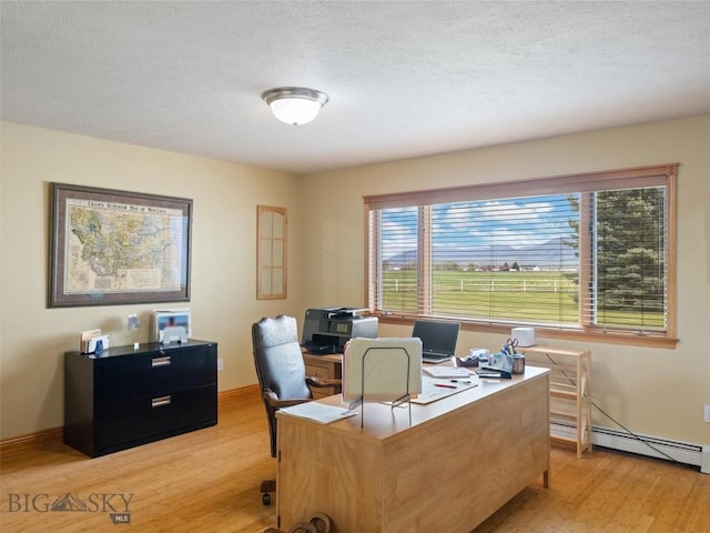 home office featuring a textured ceiling, baseboards, and light wood-style floors