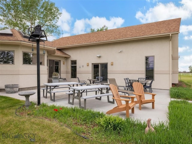 rear view of house with a patio and stucco siding