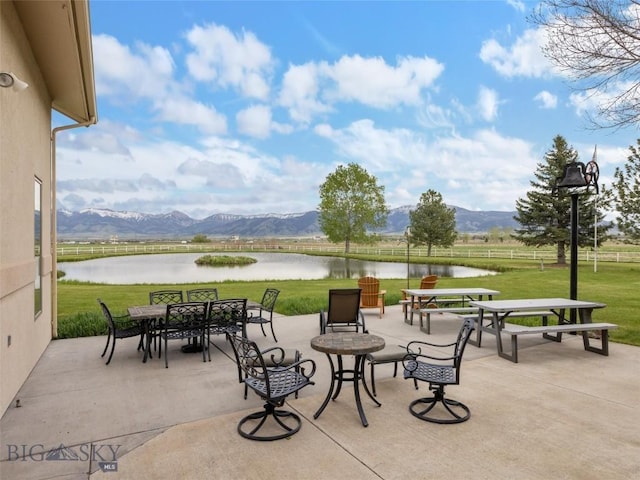 view of patio / terrace featuring a water and mountain view