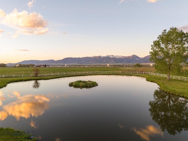 water view featuring a rural view, fence, and a mountain view