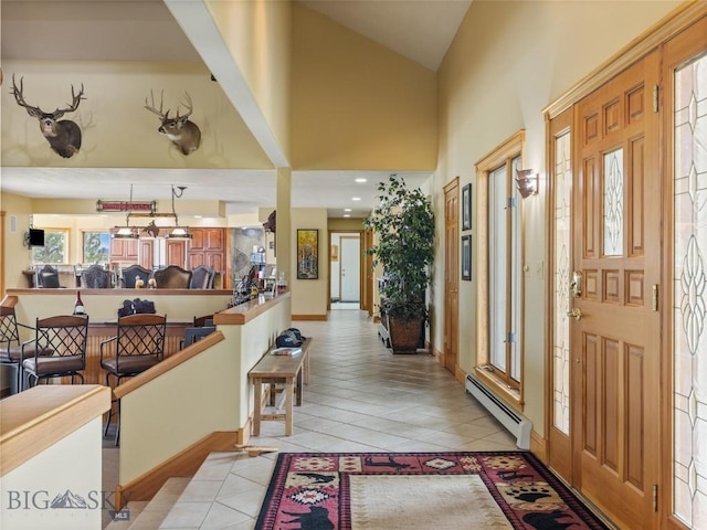 foyer entrance featuring high vaulted ceiling, a baseboard radiator, and light tile patterned floors