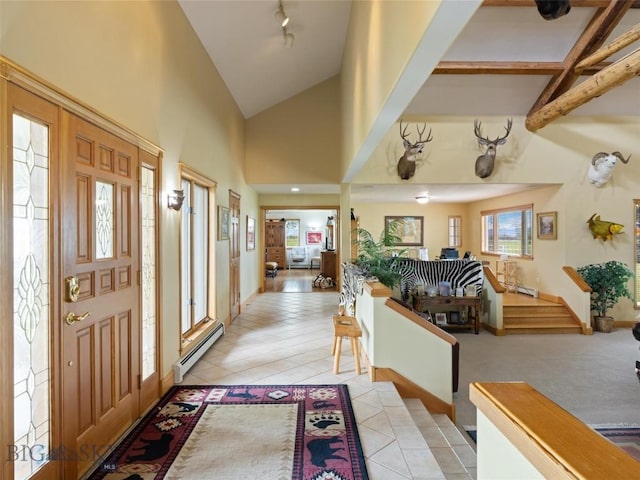 entrance foyer with a baseboard heating unit, high vaulted ceiling, light tile patterned floors, and track lighting