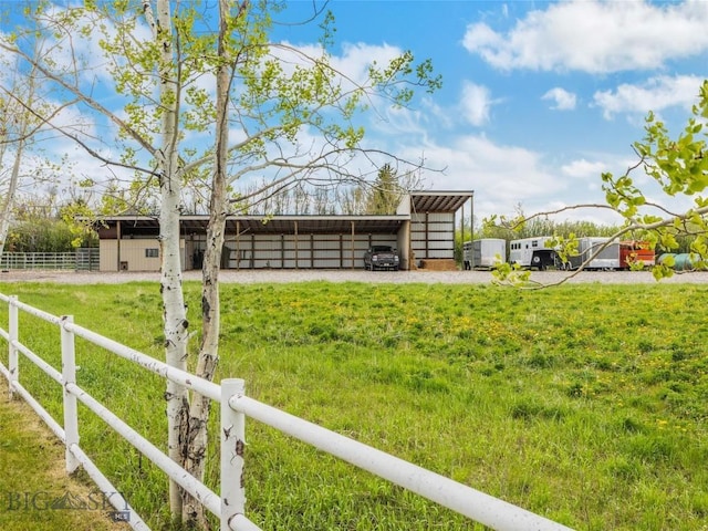 view of yard with an outbuilding, a pole building, a carport, and fence