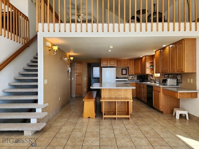 kitchen with sink, dishwasher, a center island, white fridge, and light tile patterned flooring