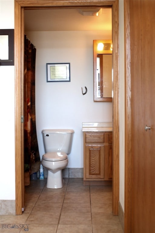 bathroom with tile patterned flooring, vanity, and toilet