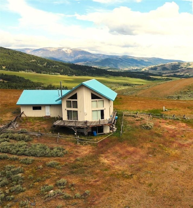 rear view of house with a mountain view and a rural view