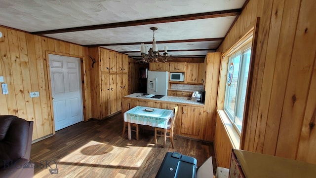 kitchen featuring beamed ceiling, dark hardwood / wood-style flooring, plenty of natural light, and white appliances