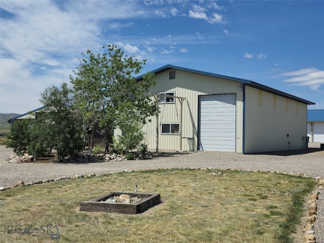 exterior space with an outbuilding, a garage, and a lawn