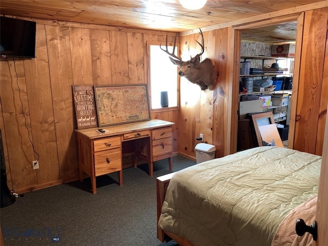 carpeted bedroom featuring wooden walls and wooden ceiling