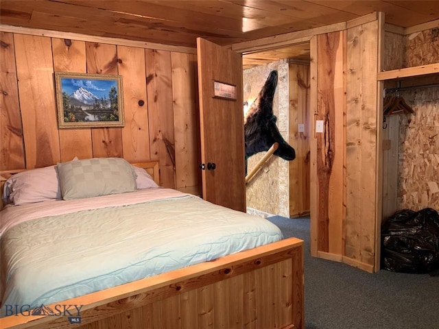 carpeted bedroom featuring wooden walls