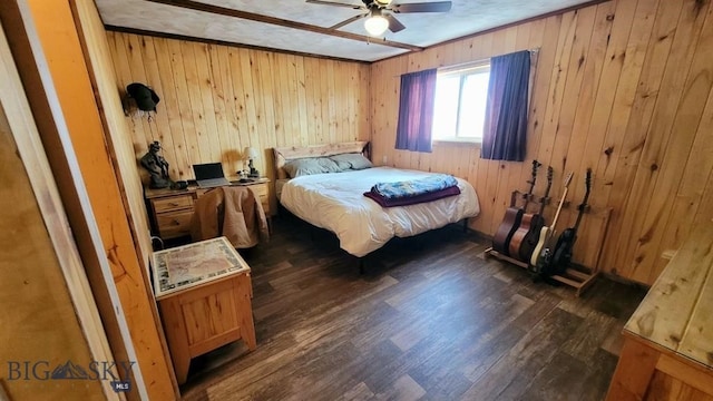 bedroom featuring ceiling fan, wood walls, dark hardwood / wood-style flooring, and ornamental molding