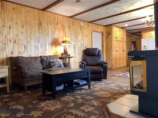 living room featuring beamed ceiling and wooden walls