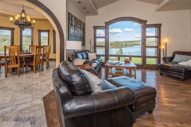 living room featuring a notable chandelier, a water view, and plenty of natural light