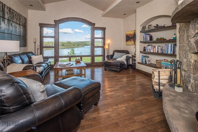 living room with built in shelves, a water view, and dark hardwood / wood-style floors