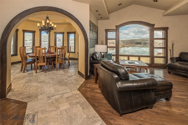 living room featuring an inviting chandelier, a water view, and a wealth of natural light