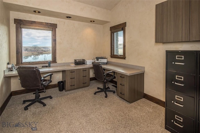 carpeted home office featuring a water view