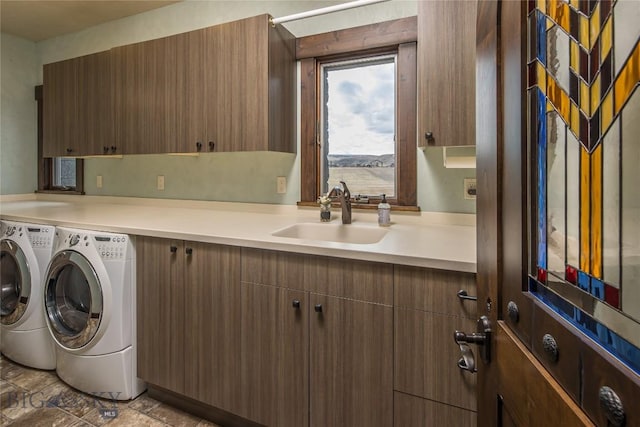 clothes washing area with sink, independent washer and dryer, and cabinets