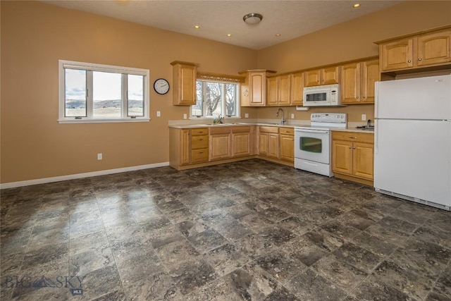 kitchen with sink, light brown cabinets, and white appliances