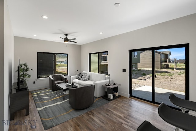 living room with dark hardwood / wood-style floors and ceiling fan