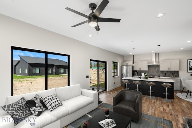 living room featuring ceiling fan and hardwood / wood-style floors