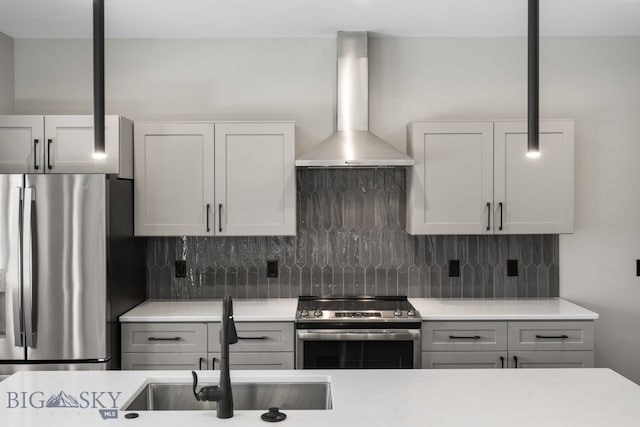 kitchen with wall chimney range hood, sink, tasteful backsplash, and stainless steel appliances