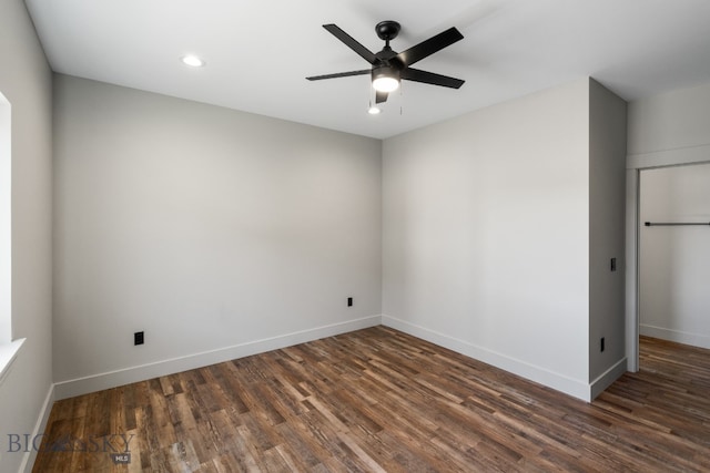 empty room featuring ceiling fan and dark wood-type flooring