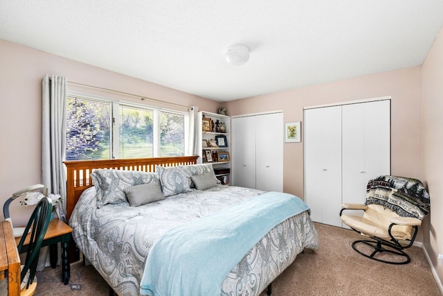 bedroom with carpet flooring and two closets