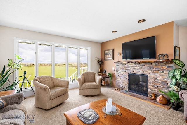 carpeted living room with a stone fireplace