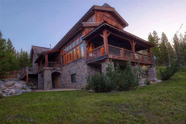 back house at dusk with a lawn