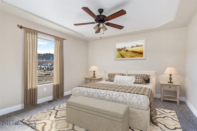 bedroom featuring a tray ceiling, ceiling fan, and carpet floors