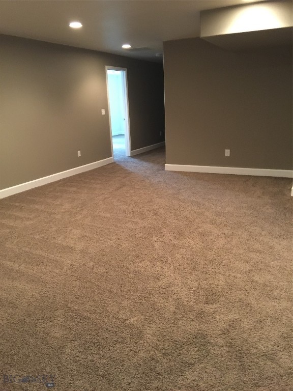 unfurnished room featuring dark colored carpet